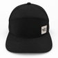Graffiti Wear all-black 7-panel snapback hat, front view with flat brim and tan leather patch