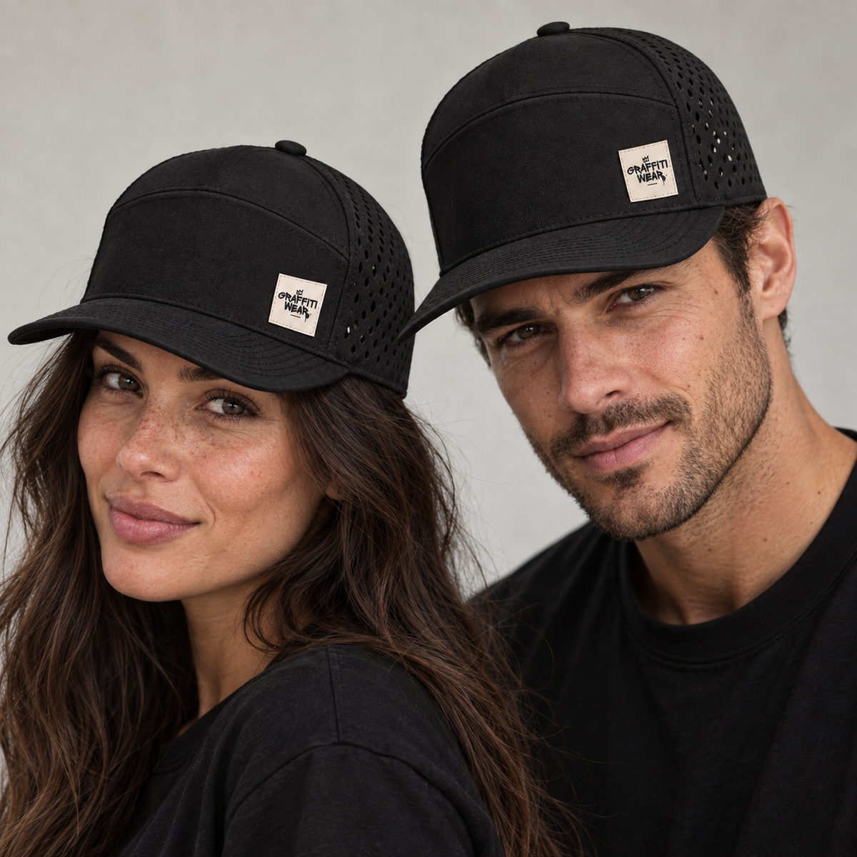 Man and woman wearing the Graffiti Wear black 7-panel snapback with tan leather patch