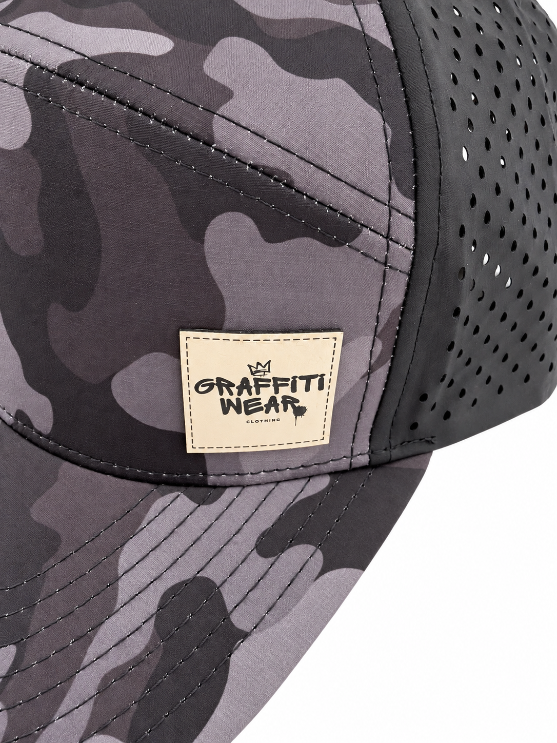 Close-up of tan leather Graffiti Wear patch on black camo snapback with perforated mesh